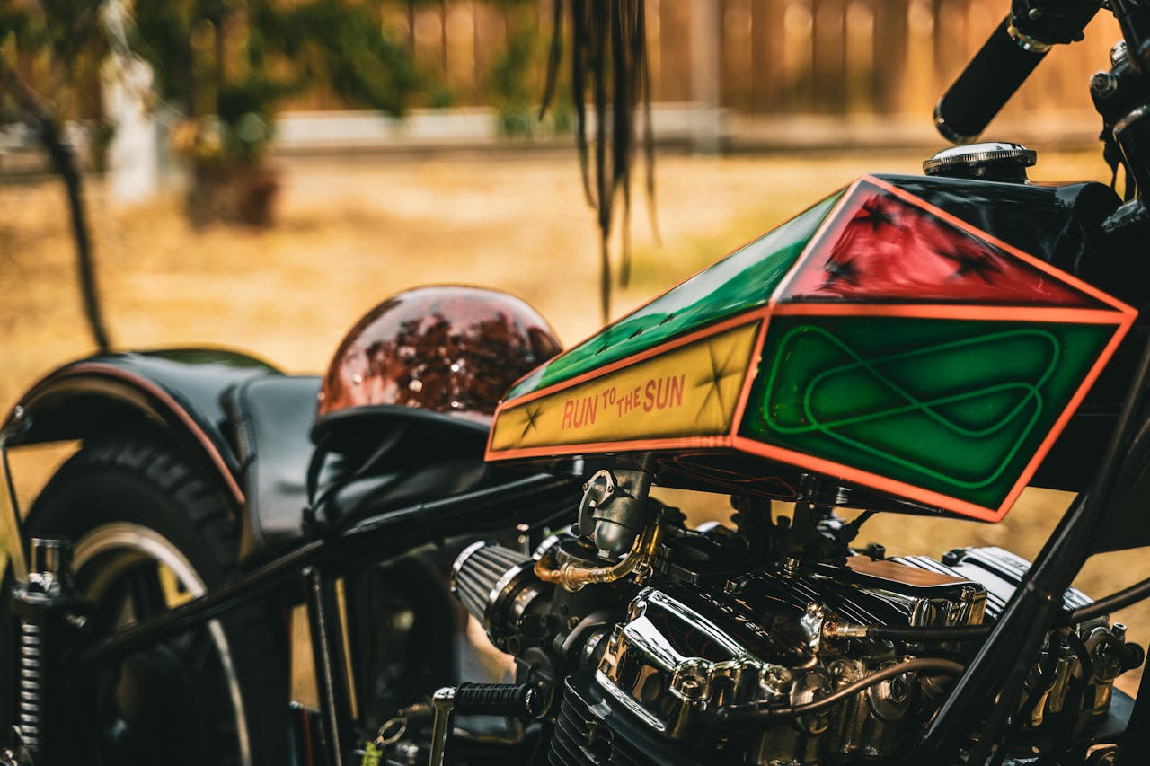 who-we-are Artistic close-up of a custom chopper motorcycle with intricate designs outdoors.